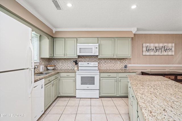 kitchen featuring white appliances, light stone countertops, green cabinets, light tile patterned floors, and ornamental molding