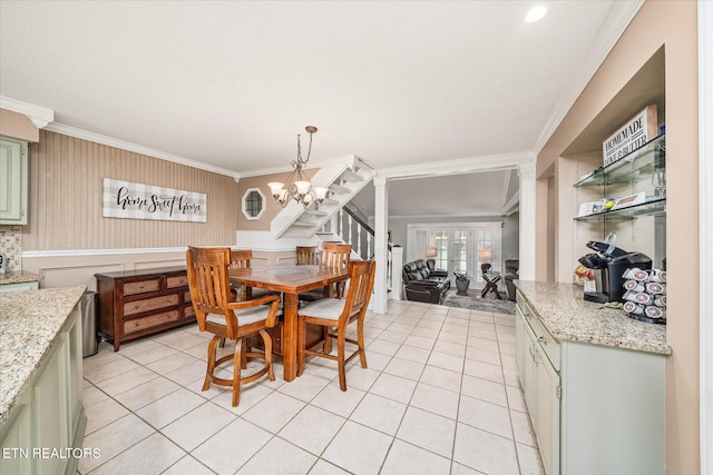 dining space with ornamental molding, a notable chandelier, and light tile patterned flooring