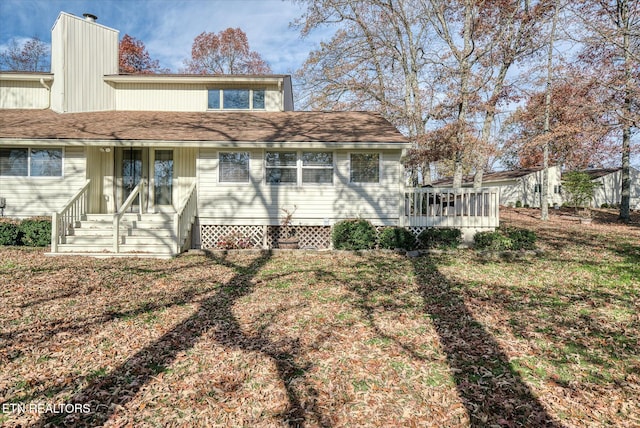 rear view of property with a lawn