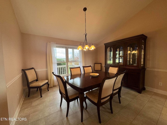 tiled dining room featuring vaulted ceiling and an inviting chandelier