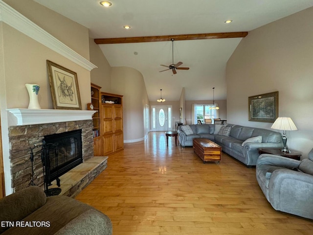 living room with beamed ceiling, ceiling fan, light hardwood / wood-style floors, and a fireplace