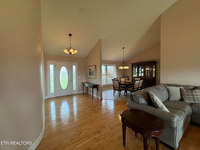 entrance foyer with high vaulted ceiling, a chandelier, and light wood-type flooring