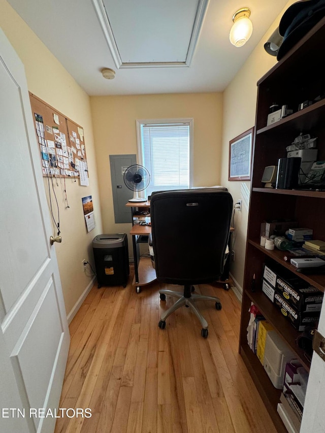 home office featuring electric panel and light hardwood / wood-style flooring