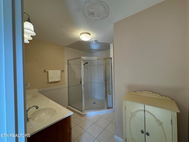 bathroom featuring tile patterned flooring, vanity, and walk in shower