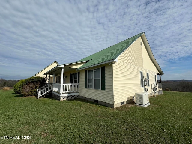 view of side of home featuring a lawn and covered porch