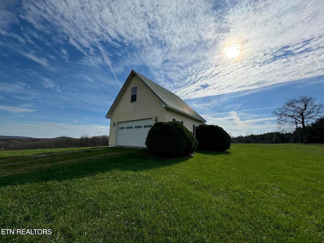 view of home's exterior featuring a lawn, a garage, and an outbuilding