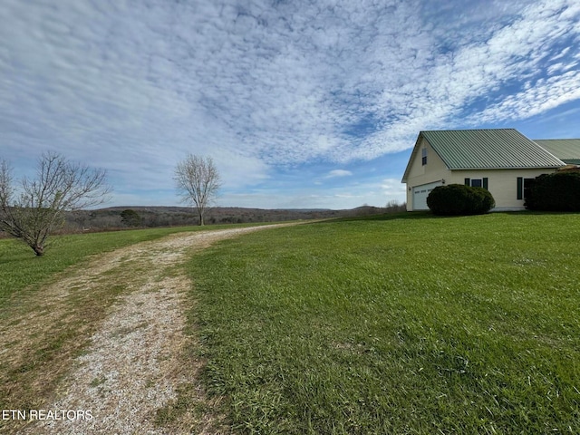 view of yard featuring a rural view and a garage