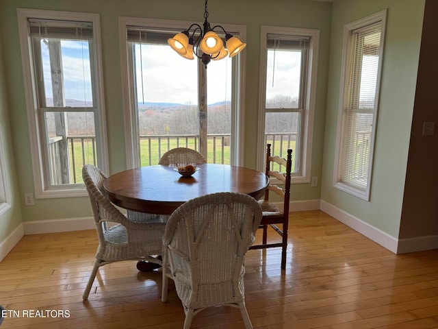 dining area with a chandelier, light wood-type flooring, and plenty of natural light