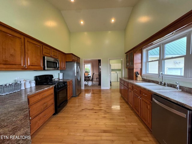 kitchen with washer and clothes dryer, sink, stainless steel appliances, and a wealth of natural light