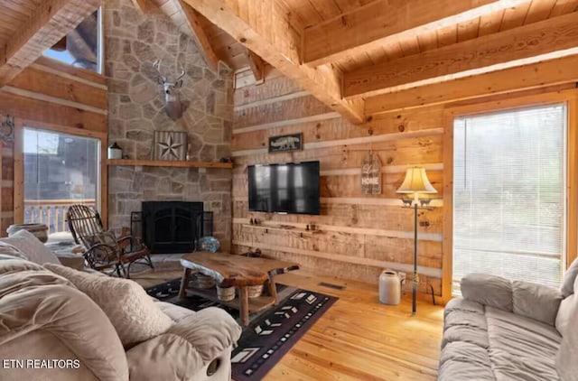 living room with high vaulted ceiling, a stone fireplace, wooden walls, hardwood / wood-style flooring, and wood ceiling