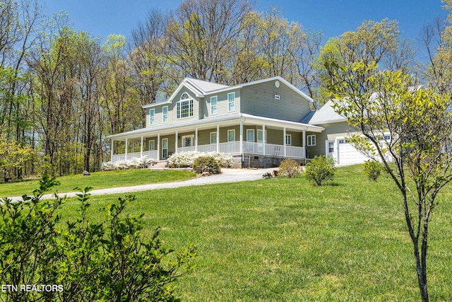 farmhouse featuring a garage, covered porch, and a front lawn