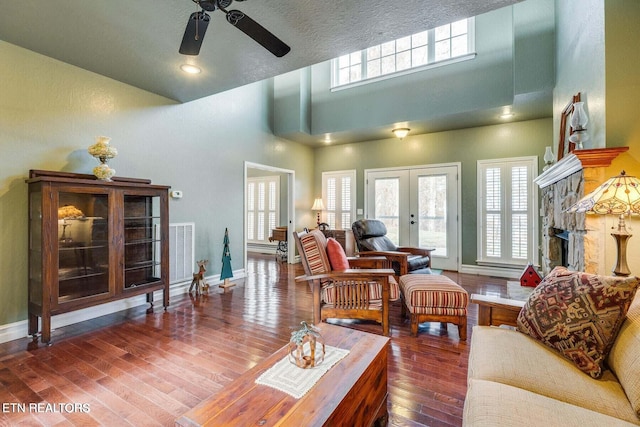 living room with french doors, a textured ceiling, ceiling fan, a high ceiling, and dark hardwood / wood-style floors