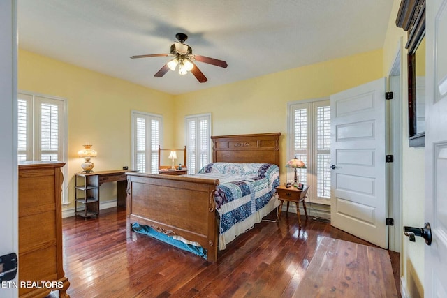 bedroom with dark hardwood / wood-style floors, ceiling fan, and multiple windows