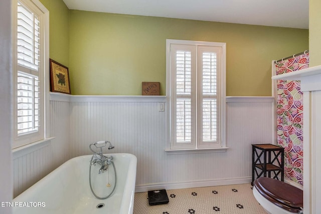 bathroom with a tub, tile patterned flooring, and toilet