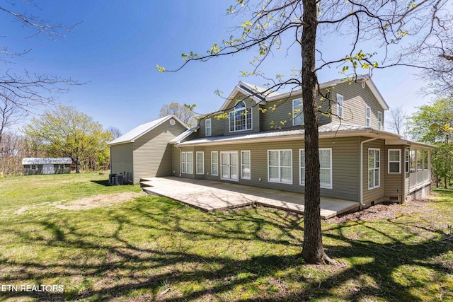 rear view of property with a lawn, cooling unit, and a patio area