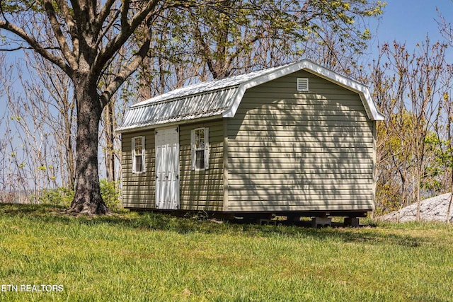 exterior space featuring an outdoor structure and a front lawn