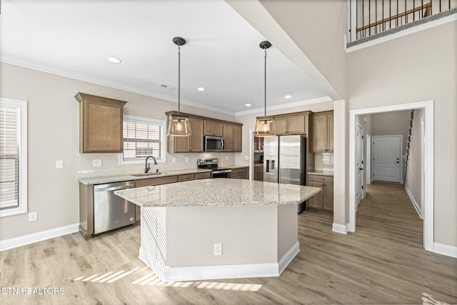 kitchen featuring a center island, stainless steel appliances, light hardwood / wood-style floors, and sink