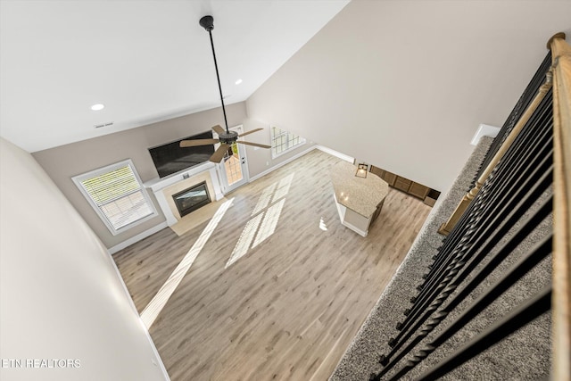 living room with ceiling fan, high vaulted ceiling, and light hardwood / wood-style floors