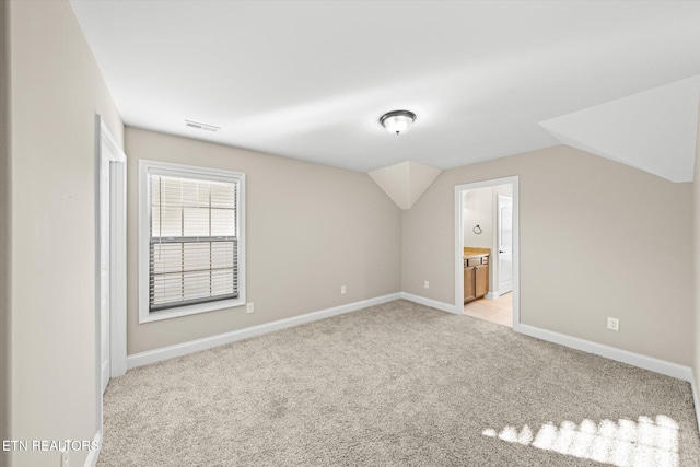 additional living space with light carpet and lofted ceiling