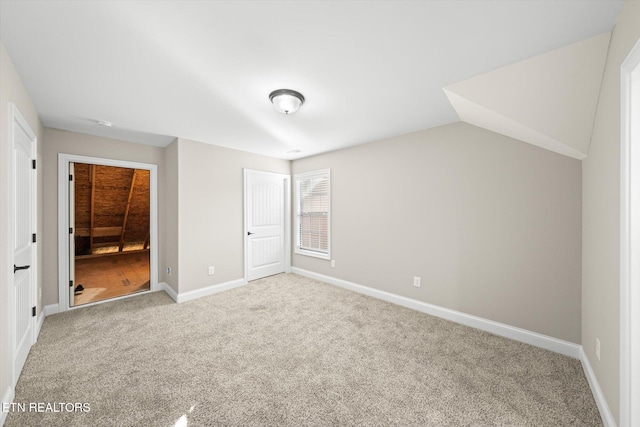 unfurnished bedroom with light colored carpet, lofted ceiling, and a closet