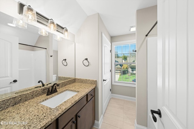 bathroom featuring tile patterned floors, vanity, toilet, and a shower