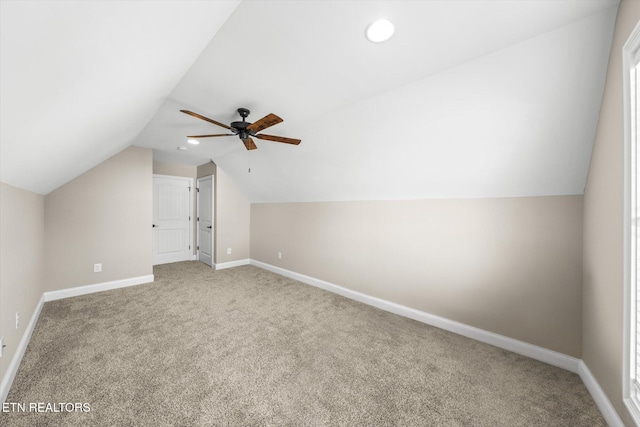 additional living space featuring ceiling fan, light colored carpet, and lofted ceiling