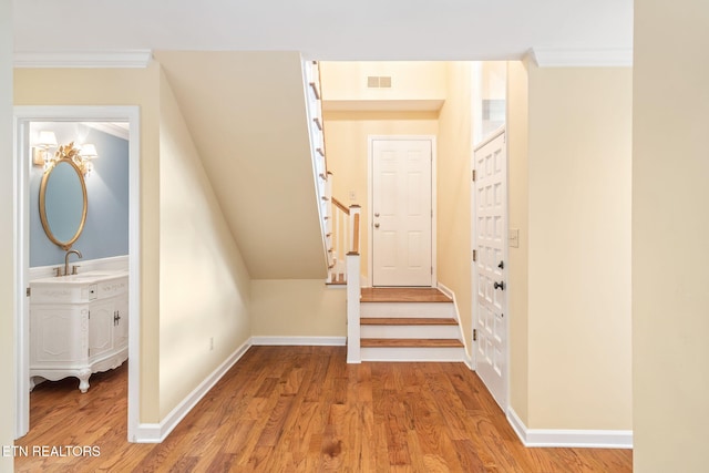 interior space with hardwood / wood-style floors, sink, and crown molding