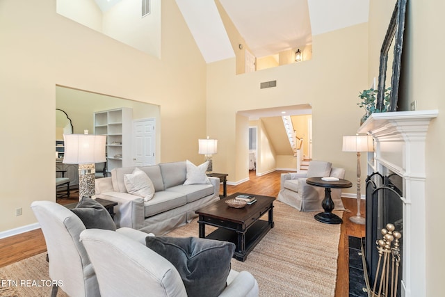 living room with light hardwood / wood-style floors and high vaulted ceiling