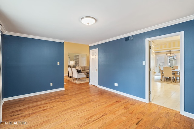 unfurnished bedroom with hardwood / wood-style flooring, ornamental molding, and a notable chandelier