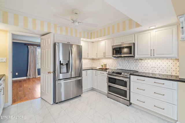 kitchen featuring white cabinets, ceiling fan, ornamental molding, light hardwood / wood-style floors, and stainless steel appliances