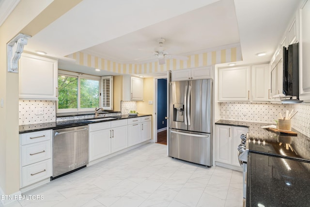 kitchen with backsplash, sink, ceiling fan, appliances with stainless steel finishes, and white cabinetry