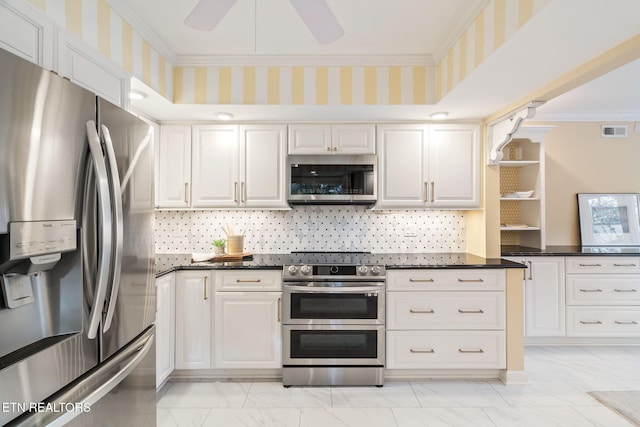 kitchen with ceiling fan, white cabinetry, stainless steel appliances, and ornamental molding