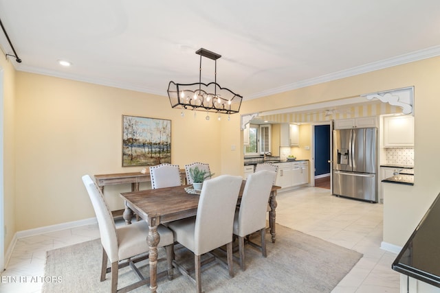 dining room with a notable chandelier, ornamental molding, and sink