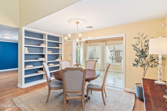 dining space with a chandelier and wood-type flooring