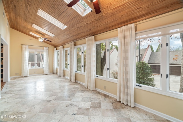 unfurnished sunroom with ceiling fan, a healthy amount of sunlight, wooden ceiling, and lofted ceiling with skylight