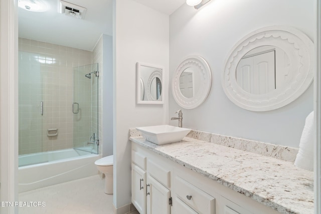 full bathroom featuring tile patterned flooring, vanity, toilet, and tiled shower / bath combo