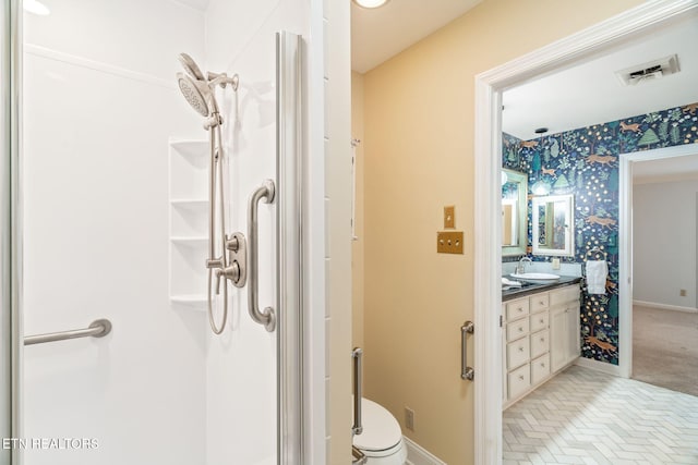 bathroom featuring a shower, vanity, and toilet