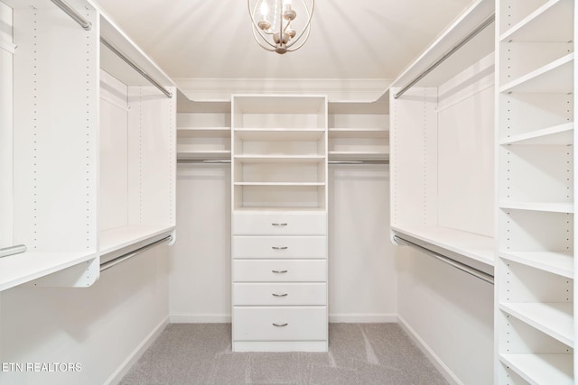 walk in closet with light colored carpet and a chandelier