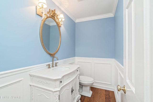 bathroom with hardwood / wood-style floors, vanity, toilet, and crown molding