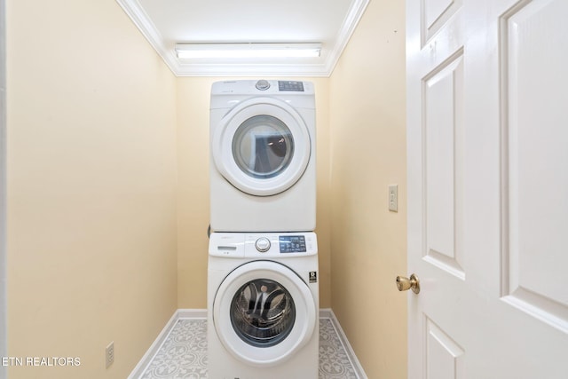 washroom with stacked washing maching and dryer and ornamental molding