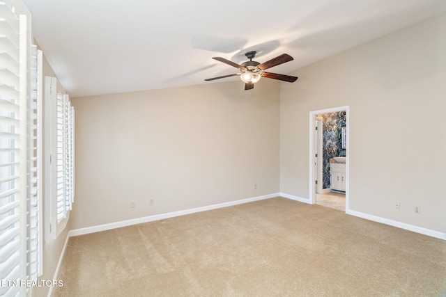 unfurnished bedroom featuring light carpet, multiple windows, lofted ceiling, and ceiling fan