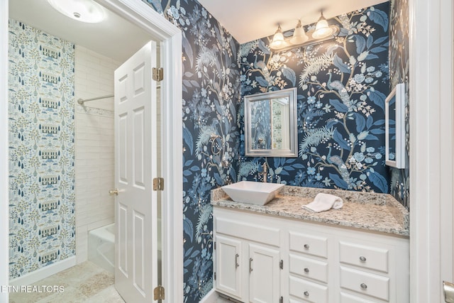 bathroom with tile patterned flooring, vanity, and tiled shower / bath