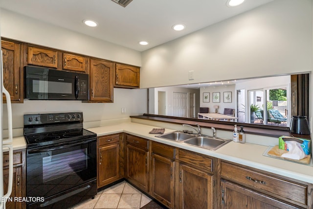 kitchen featuring black appliances, light tile patterned floors, and sink