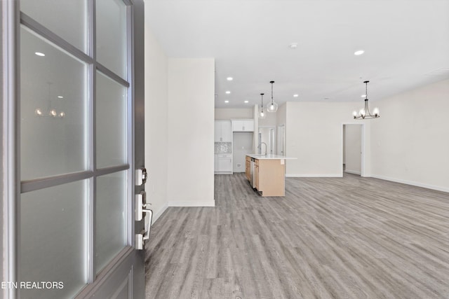 unfurnished living room with light hardwood / wood-style flooring and sink