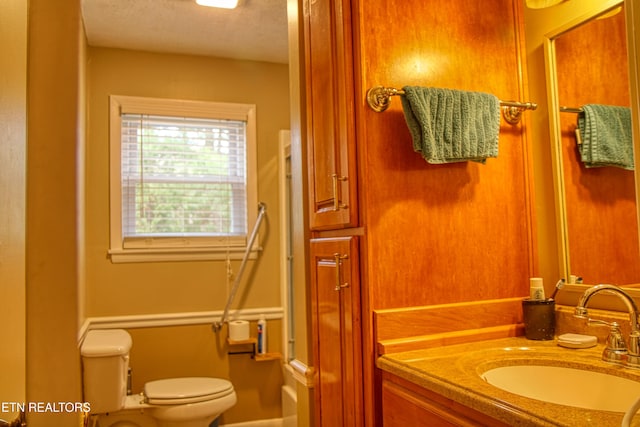 bathroom featuring vanity, a textured ceiling, and toilet