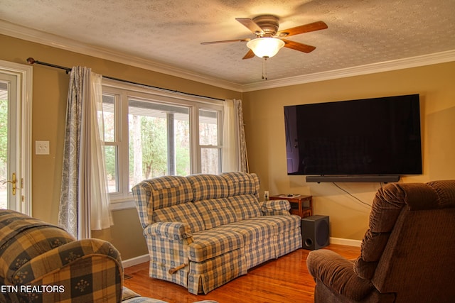 living room with hardwood / wood-style flooring, plenty of natural light, crown molding, and a textured ceiling