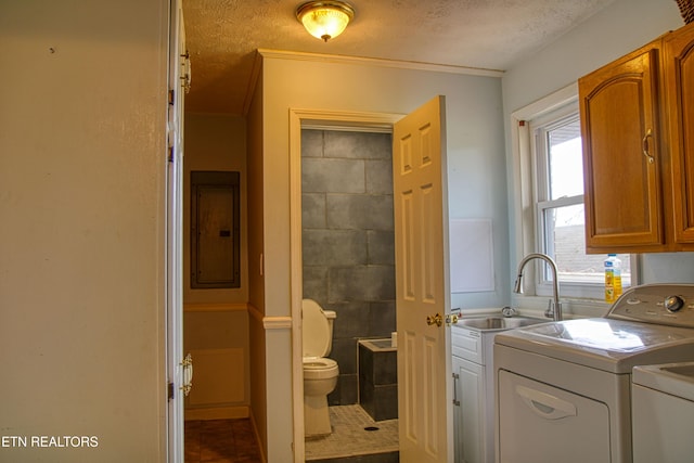 clothes washing area featuring tile patterned floors, ornamental molding, a textured ceiling, washing machine and clothes dryer, and electric panel