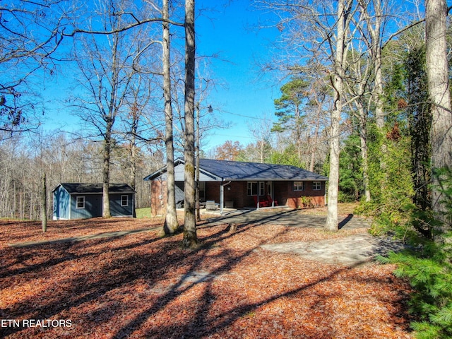 back of property featuring a shed and a patio area