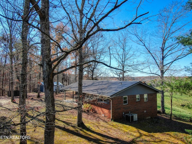 view of side of home featuring a lawn and central air condition unit