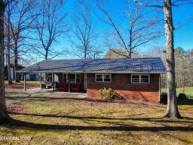 ranch-style home featuring a carport, a patio, and a front yard